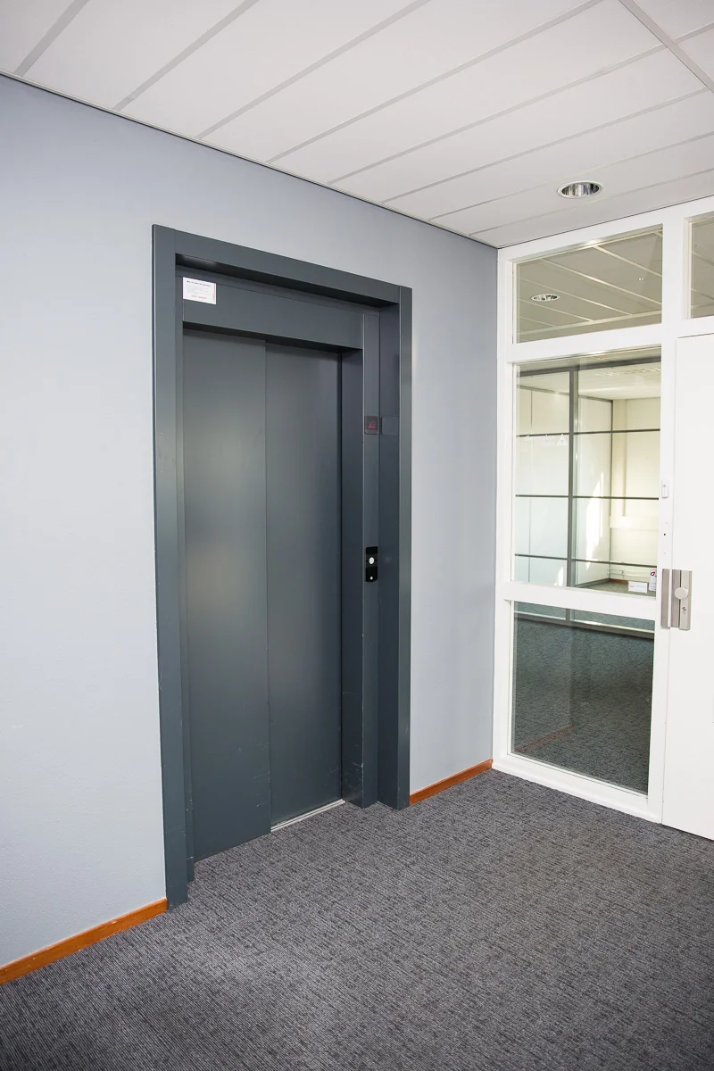 Grijze liftdeur in een modern kantoorinterieur aan de Laan van ’s-Gravenmade.